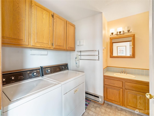 laundry area featuring a baseboard heating unit, a sink, independent washer and dryer, cabinet space, and light floors