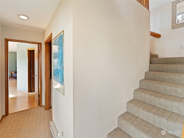 staircase featuring carpet floors and baseboard heating