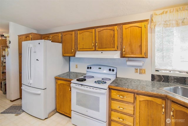 kitchen featuring sink, plenty of natural light, light tile patterned flooring, and white appliances