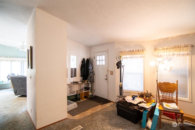 carpeted foyer with ceiling fan