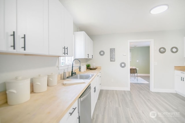 kitchen featuring sink, dishwasher, white cabinets, and light wood-type flooring