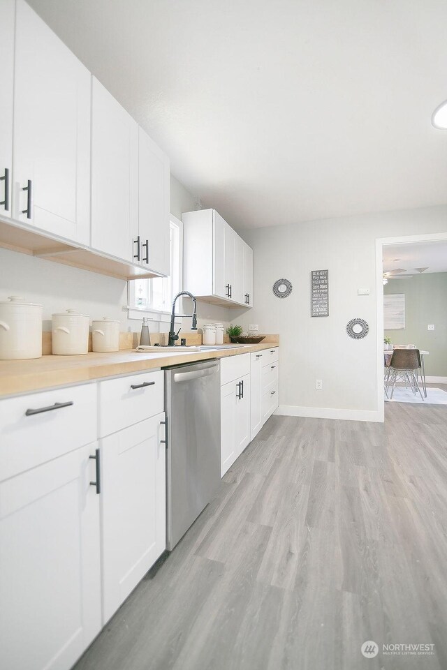 kitchen featuring ceiling fan, stainless steel dishwasher, light hardwood / wood-style flooring, white cabinetry, and sink