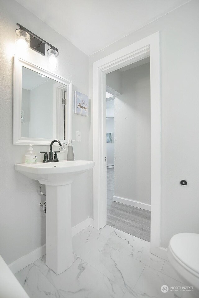 317 2nd Ave NW, Kelso, WA 98626 - half bathroom featuring baseboards, toilet, and marble finish floor