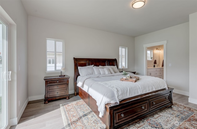 bedroom featuring ensuite bathroom and light hardwood / wood-style floors