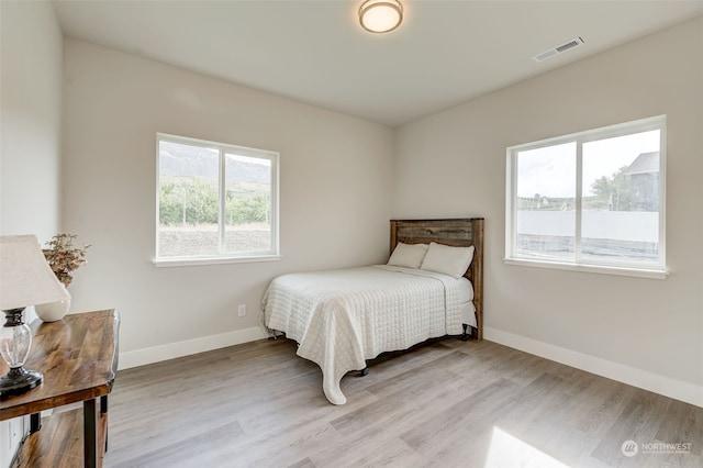 bedroom featuring multiple windows and light hardwood / wood-style floors