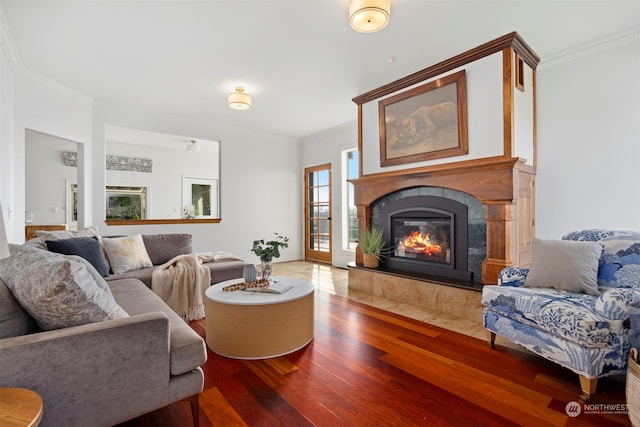 living room featuring wood-type flooring, a fireplace, and ornamental molding