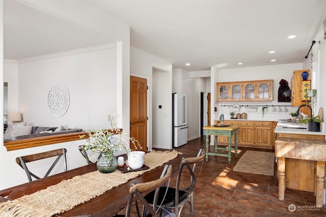 tiled dining area with sink and crown molding