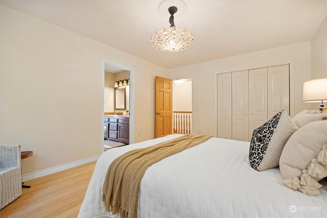 bedroom with a notable chandelier, light hardwood / wood-style floors, and a closet