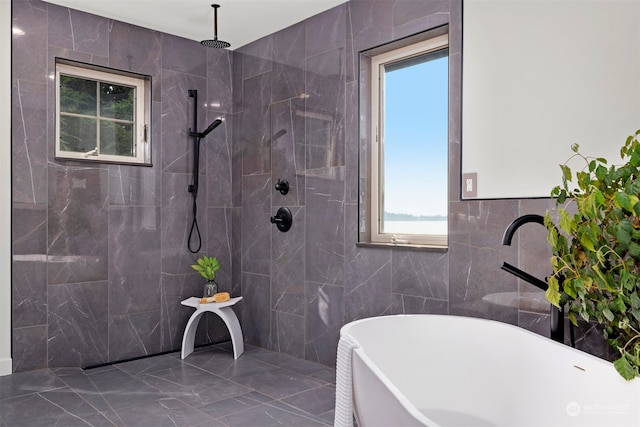 bathroom with shower with separate bathtub and tile walls