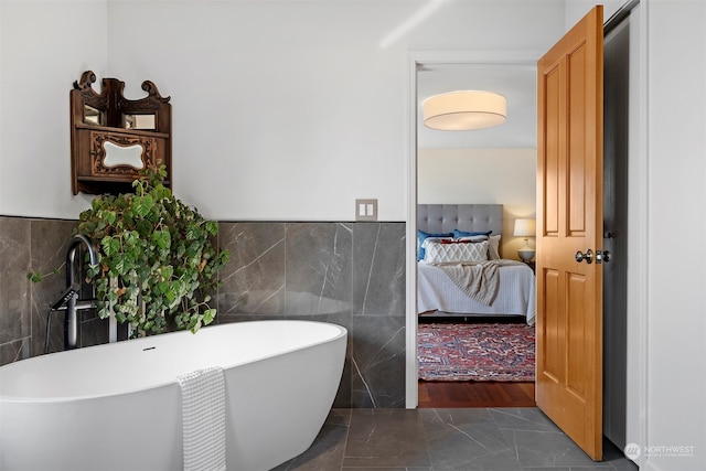 bathroom featuring tile walls, wood-type flooring, and a washtub