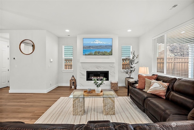 living room featuring a high end fireplace and wood-type flooring