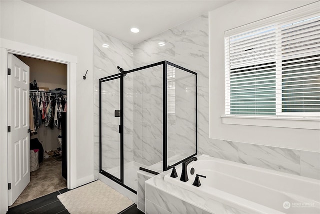 bathroom featuring separate shower and tub