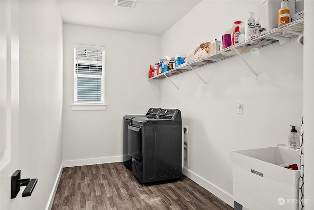 clothes washing area featuring washer and dryer, sink, and dark hardwood / wood-style floors