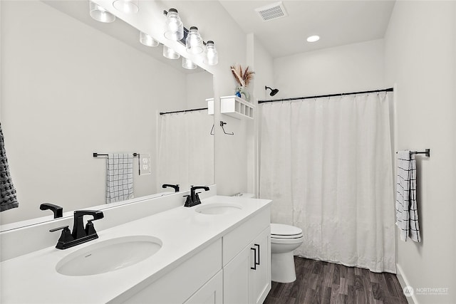 bathroom with hardwood / wood-style flooring, vanity, and toilet