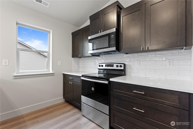 kitchen featuring dark brown cabinetry, stainless steel appliances, light hardwood / wood-style flooring, backsplash, and vaulted ceiling