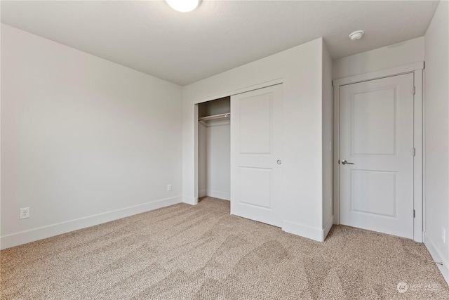 unfurnished bedroom featuring carpet and a closet