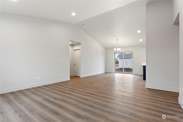 unfurnished living room with wood-type flooring, vaulted ceiling, and an inviting chandelier