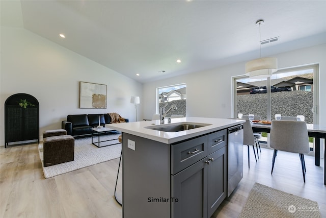 kitchen with lofted ceiling, sink, dishwasher, a kitchen island with sink, and decorative light fixtures