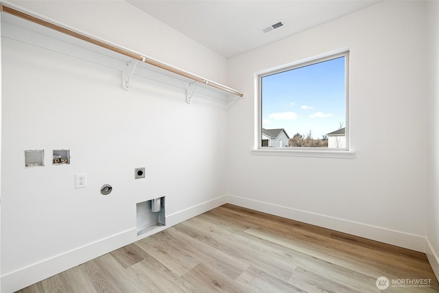 washroom featuring visible vents, hookup for an electric dryer, light wood-type flooring, laundry area, and baseboards