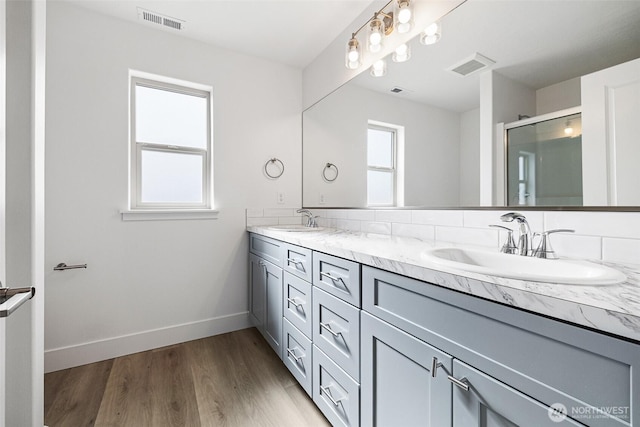 bathroom featuring a wealth of natural light, a sink, and visible vents