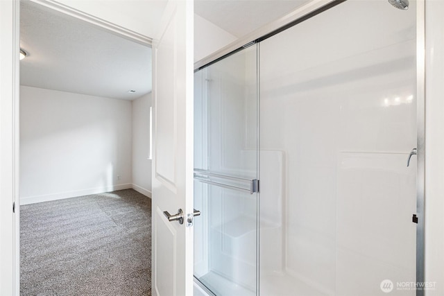 bathroom featuring a shower stall and baseboards