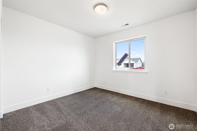 unfurnished room featuring baseboards, visible vents, and dark colored carpet