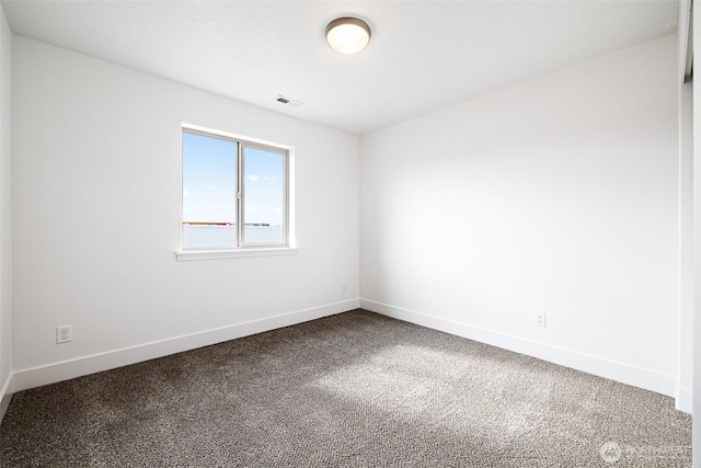 empty room featuring carpet floors, visible vents, and baseboards