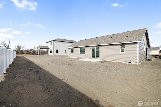 back of property featuring a shingled roof, fence, and central air condition unit