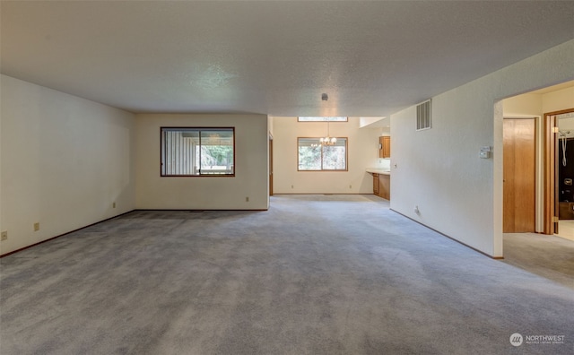 carpeted empty room featuring a textured ceiling