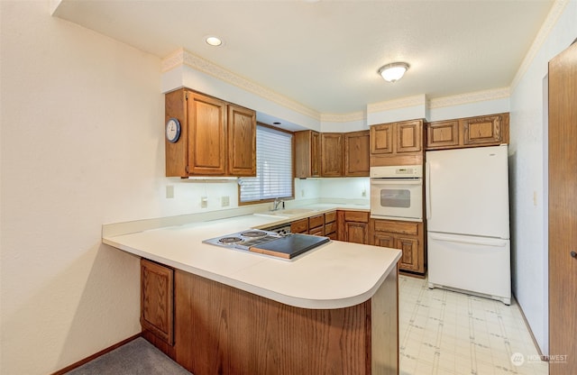 kitchen featuring white appliances, light tile patterned floors, a breakfast bar, sink, and kitchen peninsula