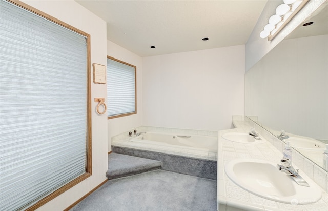 bathroom with a bathtub and dual vanity