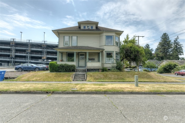 view of front of house with a front yard and a porch