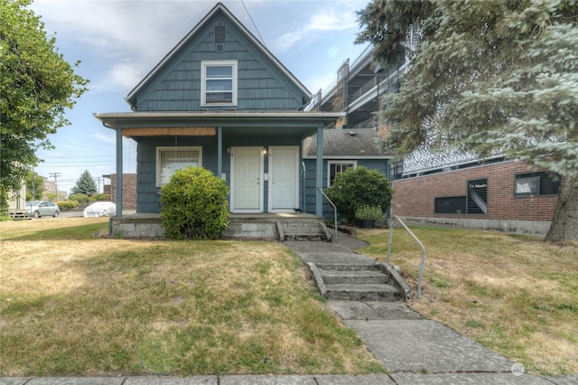 bungalow with a porch and a front lawn