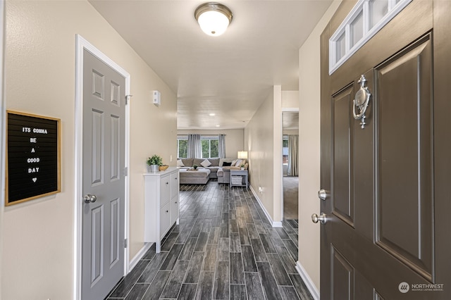 foyer featuring dark carpet