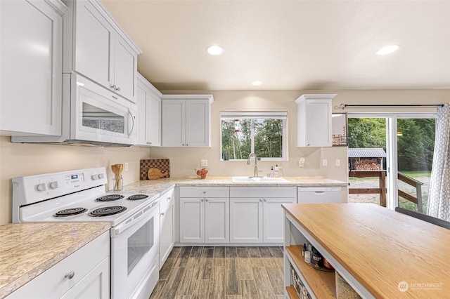 kitchen with white cabinets, white appliances, sink, and plenty of natural light