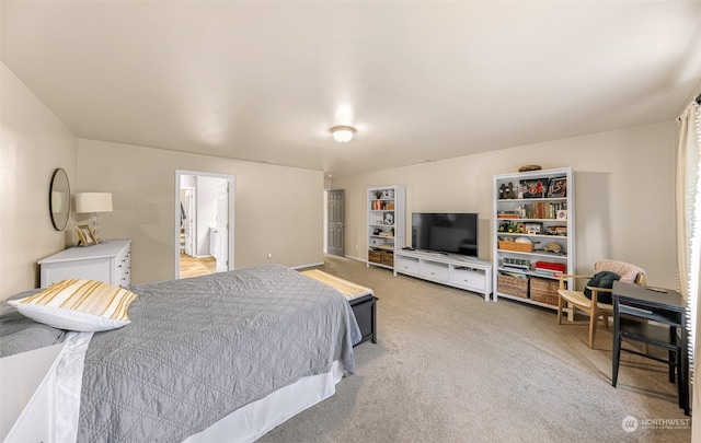 bedroom with connected bathroom and light colored carpet