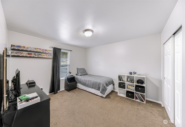 carpeted bedroom with a textured ceiling and a closet