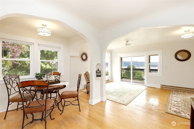 dining area featuring light wood-type flooring and a baseboard radiator