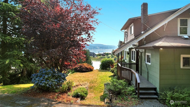 view of yard with a deck with water view