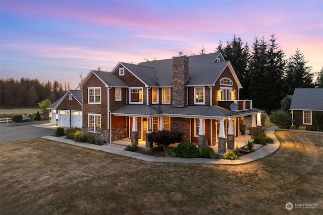 view of front of house with stone siding, a porch, and a front yard