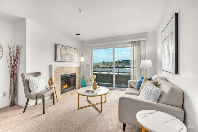 carpeted living room featuring a fireplace and a water view