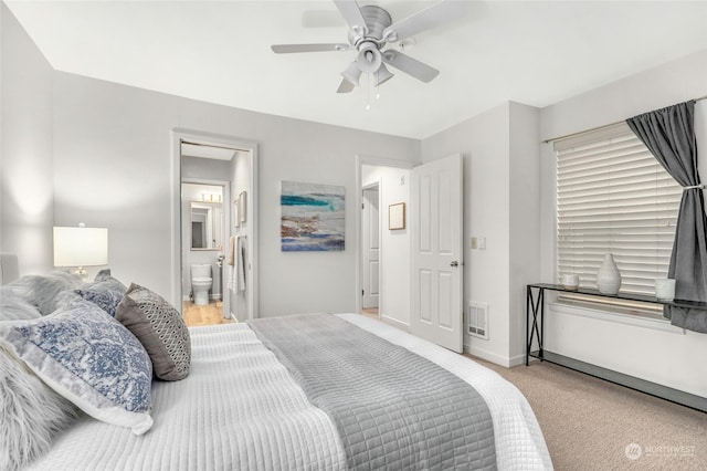 bedroom featuring ceiling fan, ensuite bath, and light colored carpet