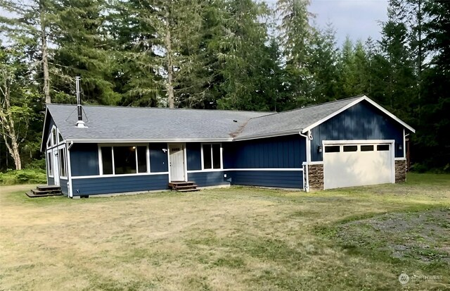 single story home featuring a front lawn and a garage