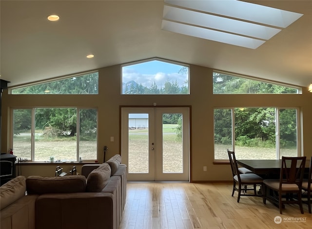 doorway to outside with light wood-type flooring, lofted ceiling, french doors, and recessed lighting