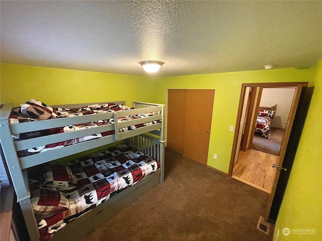 carpeted bedroom featuring visible vents and a textured ceiling