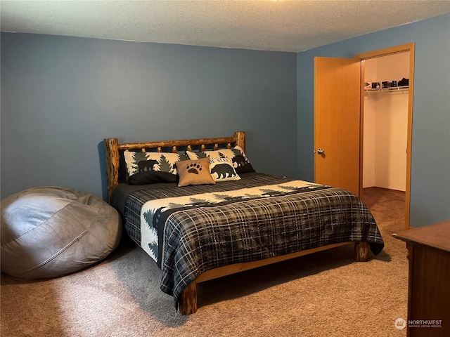 bedroom featuring carpet floors, a closet, a spacious closet, and a textured ceiling