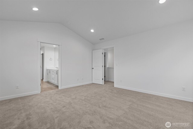 20221 148th St E Unit 611, Bonney Lake, WA 98391 - unfurnished bedroom featuring recessed lighting, vaulted ceiling, light carpet, and ensuite bathroom