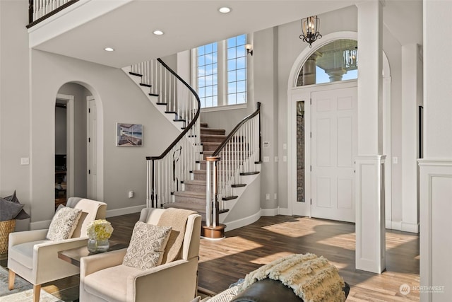 entrance foyer featuring a towering ceiling and hardwood / wood-style floors