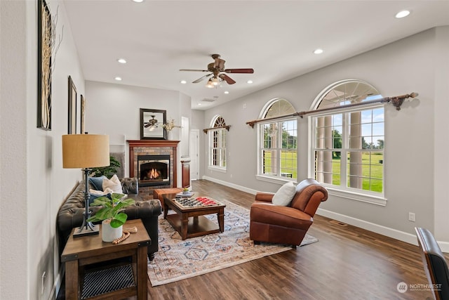 living room featuring a brick fireplace, ceiling fan, and wood-type flooring