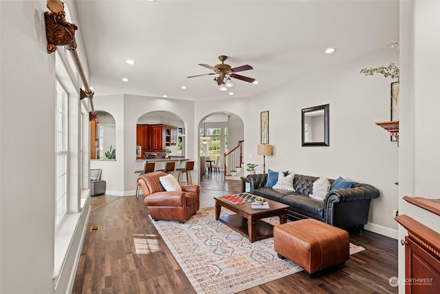 living room with ceiling fan and dark wood-type flooring